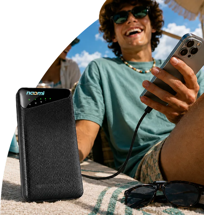 A traveler staying online and charging a phone with one pocket Noomi device